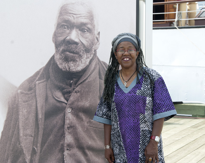Poet, documentarian and educator Sylvia D. Hamilton stands in front of a photo of Gabriel Hall, one of 2000 former American slaves who settled in Nova Scotia and New Brunswick after the War of 1812. Photo by Joseph Muise