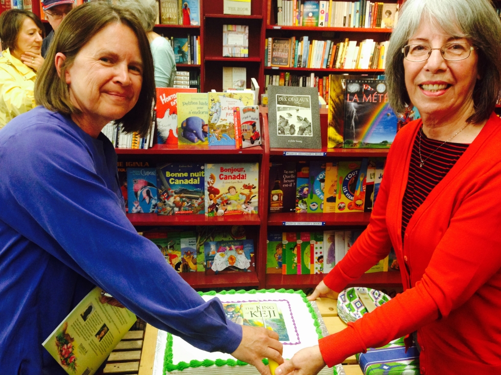 Author Jan Coates (L) and illustrator Patsy MacKinnon (R) cut the cake at their "King of Keji" book launch at the Box of Delights Book Shop in Wolfville, NS, on Saturday, June 6. Photo courtesy of Nimbus Publishing.