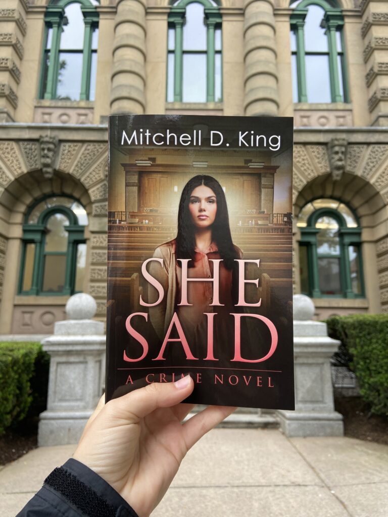 A copy of She Said is held before a courthouse in Halifax.